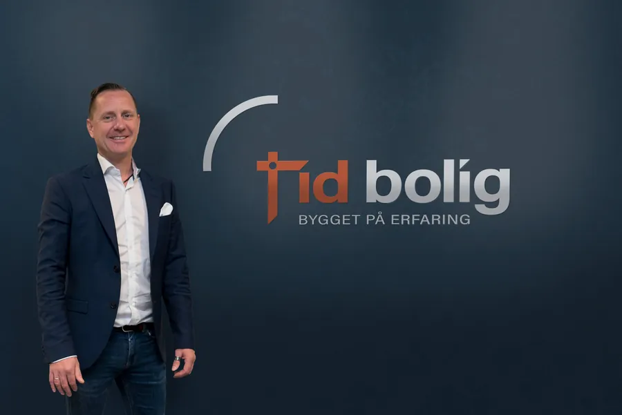 Fra kontoret til Tid Bolig, foran logoveggen