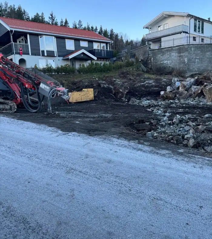 Borerigg på tomten under en mur
