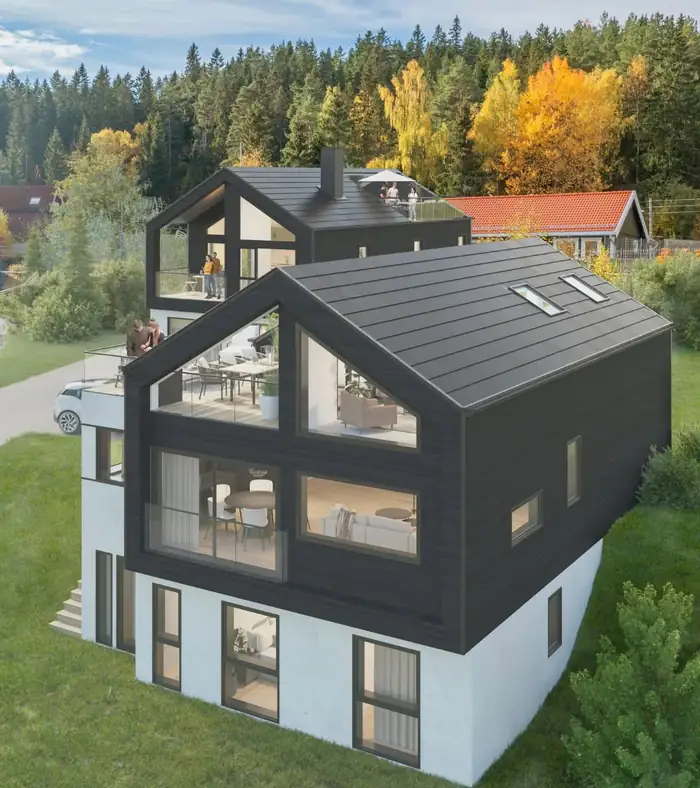 Svart hus med saltak og store vinduer i en skråning